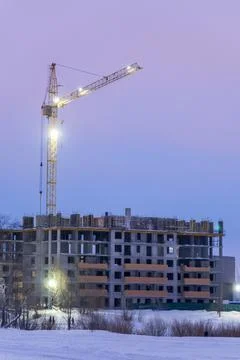Construction engineering project with cranes. Winter building work. Vertical  Stock Photos