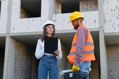 Construction engineers inspecting building progress at construction site Stock Photos