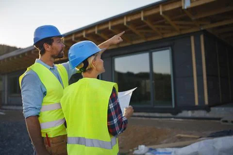 Construction engineers or architects with blueprints checking eco building site Fotos de archivo