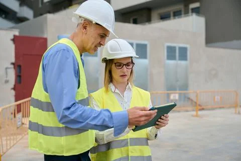 Construction engineers planning project details using tablet Stock Photos
