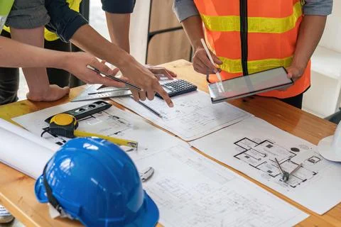 Construction engineers team using blueprint and tablet of project plan Stock Photos