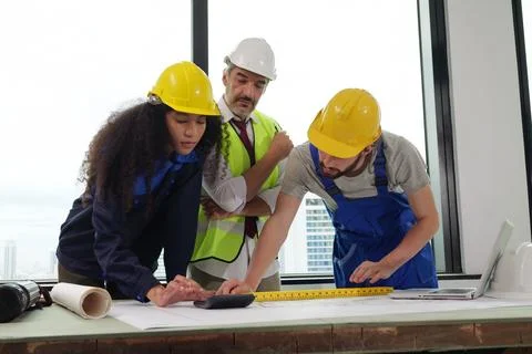 Construction engineers team using blueprint of project plan Stock Photos