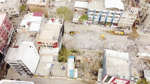Construction equipment clearing a debris field with houses destroyed Stock Footage 258092310