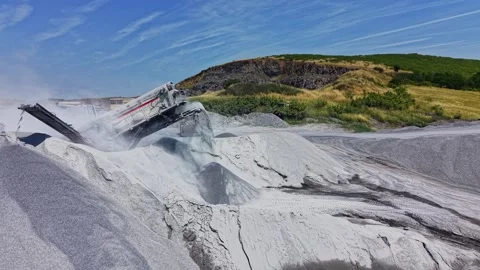 Construction equipment moves sand at a quarry site during the day Stock Footage 339054017