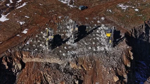 Construction equipment on rocky terrain at a mining site in winter Stock Footage 337940378