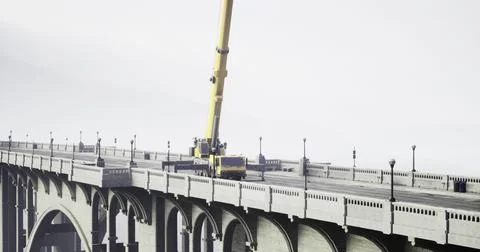 Construction equipment working on a bridge during overcast weather Stock Illustration
