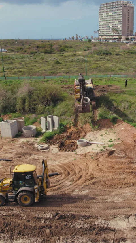 Construction excavator crane working coastal residential housing development Stock Footage 315646606