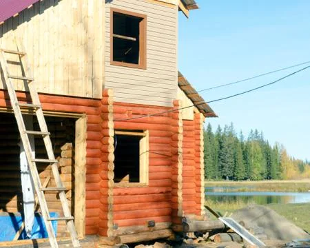 Construction of the facade of a new house made of pine timber with stairs lea Stock Photos
