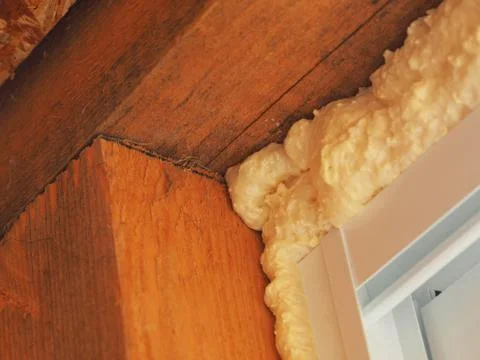 Construction foam sealed the gap between the plastic window and the wooden wa Stock Photos