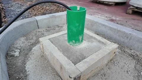 Construction footage of green utility pipe installed inside concrete base Stock Footage 335220101