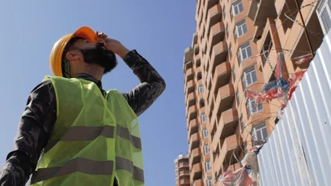Construction foreman in a helmet near the construction site of a building. 4 k Stock Footage 106019776