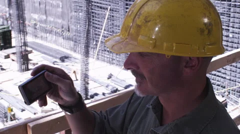 Construction Foreman on Job Site Talks into Phone Stock Footage 62887774
