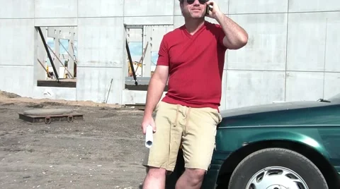 Construction Foreman Looking at Blueprints &amp; Talking on Phone 스톡 동영상 65745743