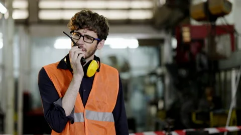 Construction foreman working on walkie-talkie talking in industrial factory. Stock Footage 157275942