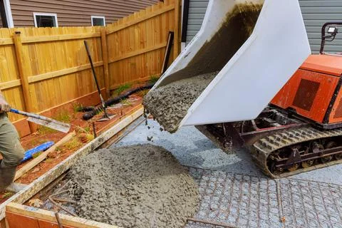 Construction of foundation involves pouring of wet cement into framework using a Stock Photos