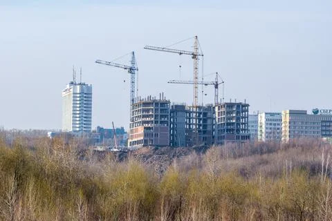 Construction of a frame building with three tower cranes. The new building of Stock Photos