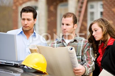 Construction: group studies blueprints and computer plans Stock Photos