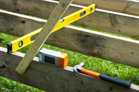 A construction hammer, a box of nails and a construction level Stock Photos