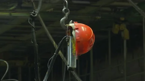 The construction helmet of a factory worker hangs on the control panel of a cran Stock-Footage 189915245