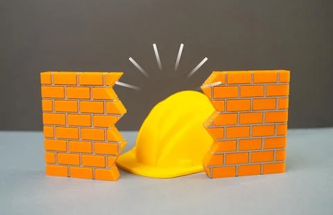Construction helmet visible through a hole in the wall, repair and reconstr.. Stock Photos