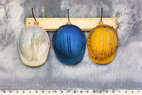 Construction helmets hanging on a hat-rack Stock Photos