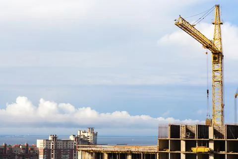 Construction of a high-rise building with a crane. The construction crane and Stock Photos