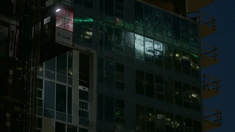 Construction Hoist Descending Modern Skyscraper at Night Stock Footage 344612818