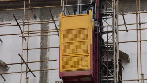 A construction hoist is moving in the construction site Stock Footage 314522079