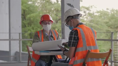 Construction of a hospital, builders sitting at a table discussing the project Stock Footage 134406326