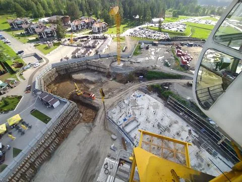 Construction of a hotel with the help of tower cranes, in the mountains against Stock Photos