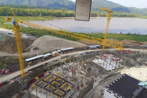 Construction of a hotel with the help of tower cranes, in the mountains against Stock Photos