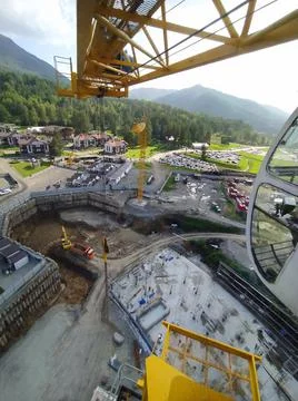 Construction of a hotel with the help of tower cranes, in the mountains against Stock Photos