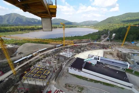Construction of a hotel with the help of tower cranes, in the mountains against Stock Photos