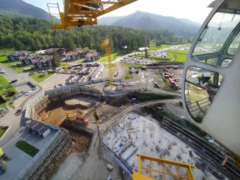 Construction of a hotel with the help of tower cranes, in the mountains against Stock Photos