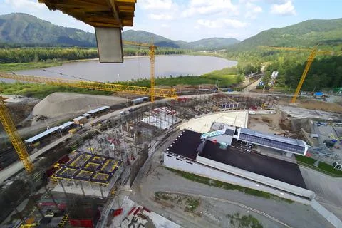 Construction of a hotel with the help of tower cranes, in the mountains against Stock Photos