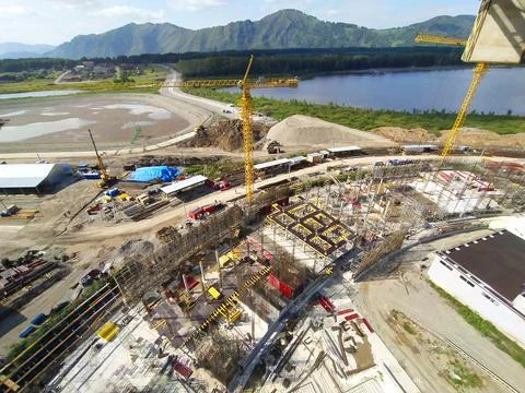 Construction of a hotel with the help of tower cranes, in the mountains against Stock Photos
