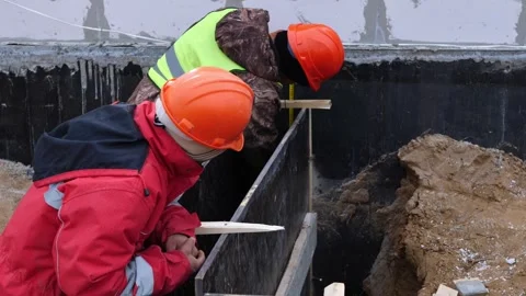 Construction of a house. Builders measure the facade of a brick house Stock Footage 321003808