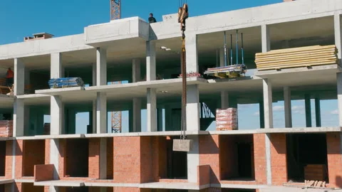 Construction of a house. A construction crane lowers the load. Work at the Video stock 247326948