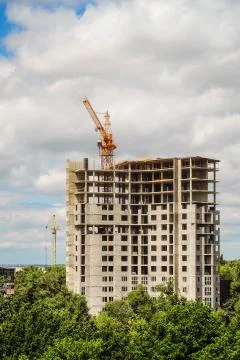 Construction of house. High-rise tower crane with a multi-storey building. Stock Photos