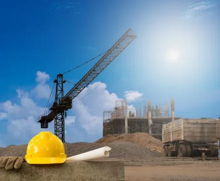 Construction industry building on high ground with yellow helmet and paper wo Stock Photos