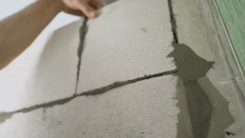 Construction Of Internal Walls In. A worker builds a wall of white blocks inside Video stock 155622778