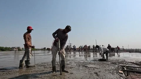 Construction laborer using a concrete vibrator tool on a building slab Stock Footage 343910944