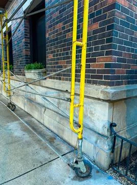 Construction ladder and tools on brick building stairs Stock Photos
