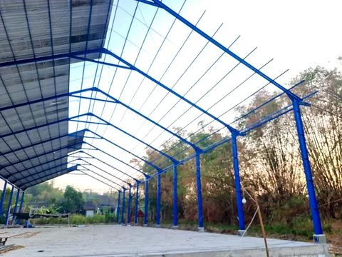 Construction of a large blue steel frame warehouse structure. Fotos Stock