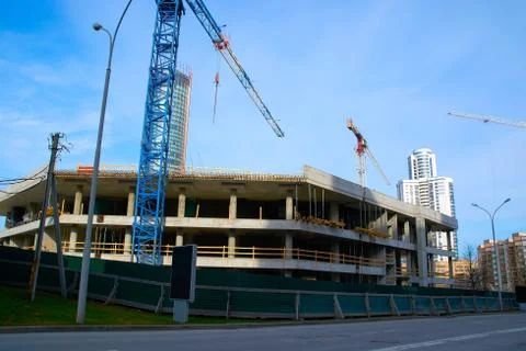 Construction of a large building with construction cranes in the city Stock Photos