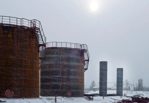 Construction of large fuel tanks during a snowstorm Stock Photos