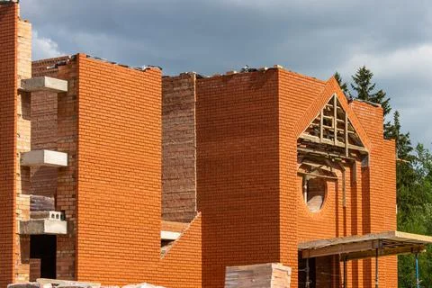 Construction of a large red brick Catholic church. High, even walls of a bric Stock Photos