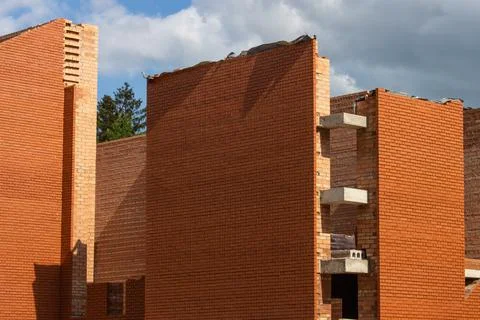 Construction of a large red brick Catholic church. High, even walls of a bric Stock Photos