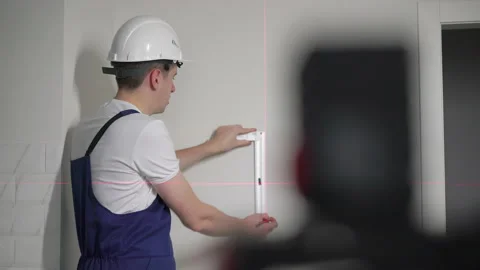 Construction laser level. Builder worker makes repairs in the apartment. 動画素材 171143943