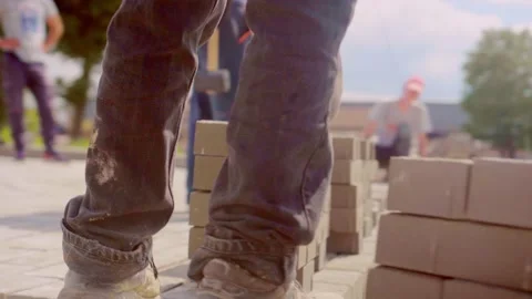 Construction, laying paving slabs by a team on a sunny day. Video stock 156038180